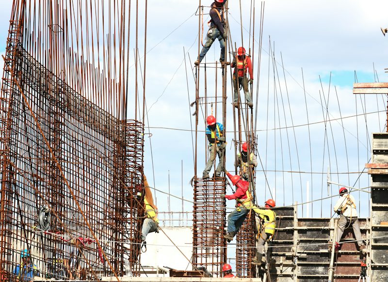 Workers on scaffolding fixing column reinforcement