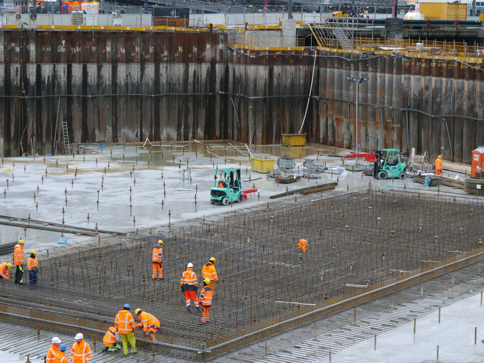 Crew laying reinforcement in a large foundation excavation