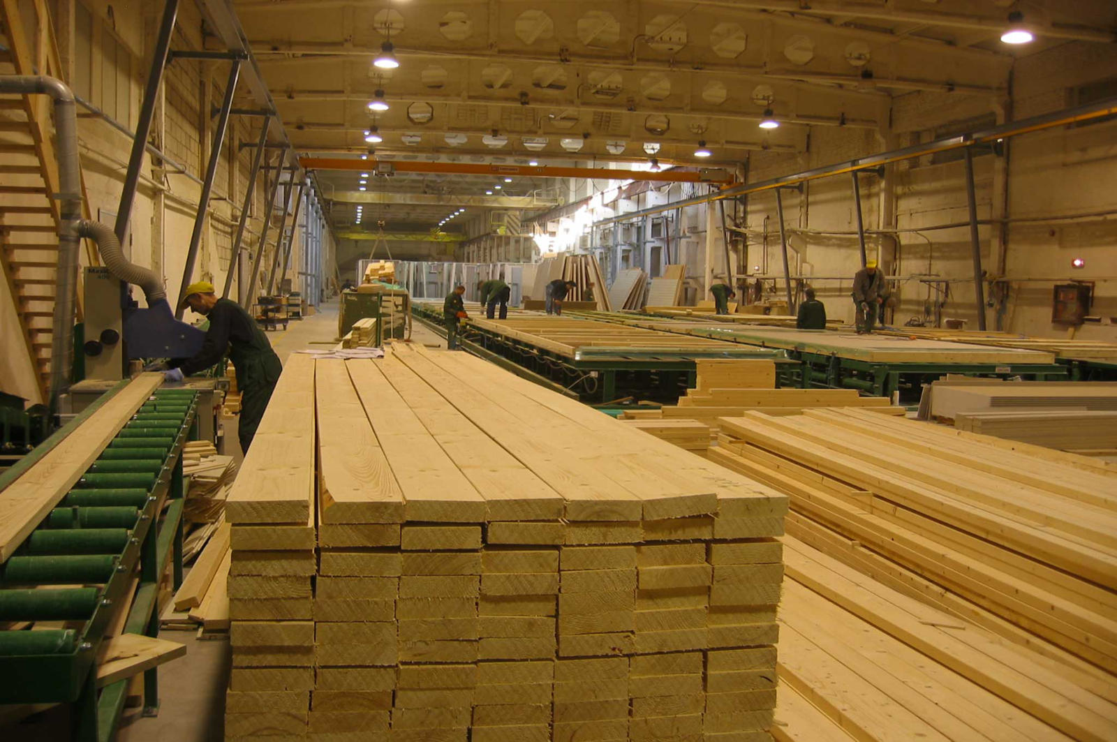 Sawn timber on a conveyor inside a timber processing hall